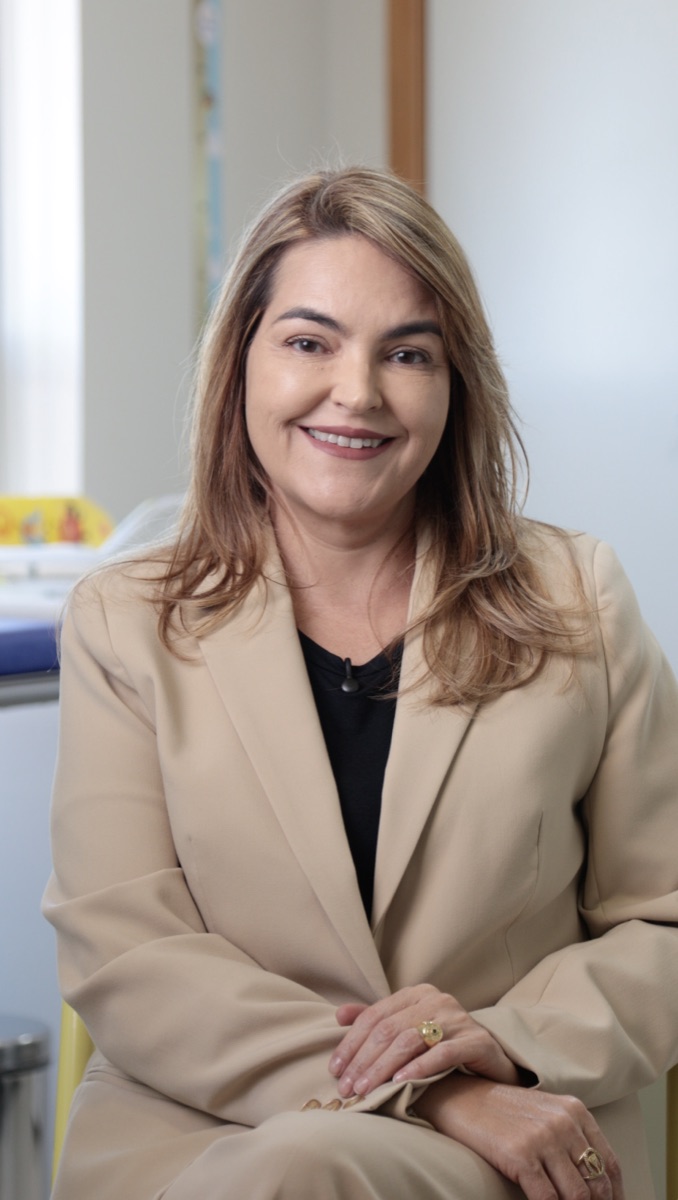 Dra. Michelle Machado, pediatra alergista, sorrindo no consultório